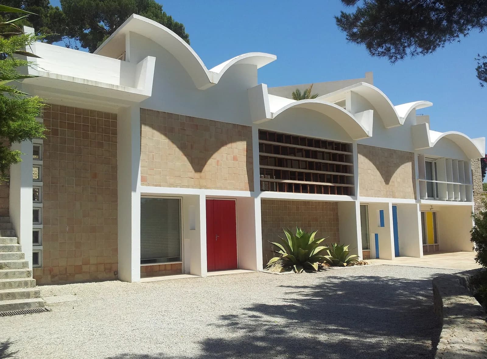 Façade de l’atelier Sert de la Fondation Miró à Palma, avec son toit ondulé blanc et ses portes colorées