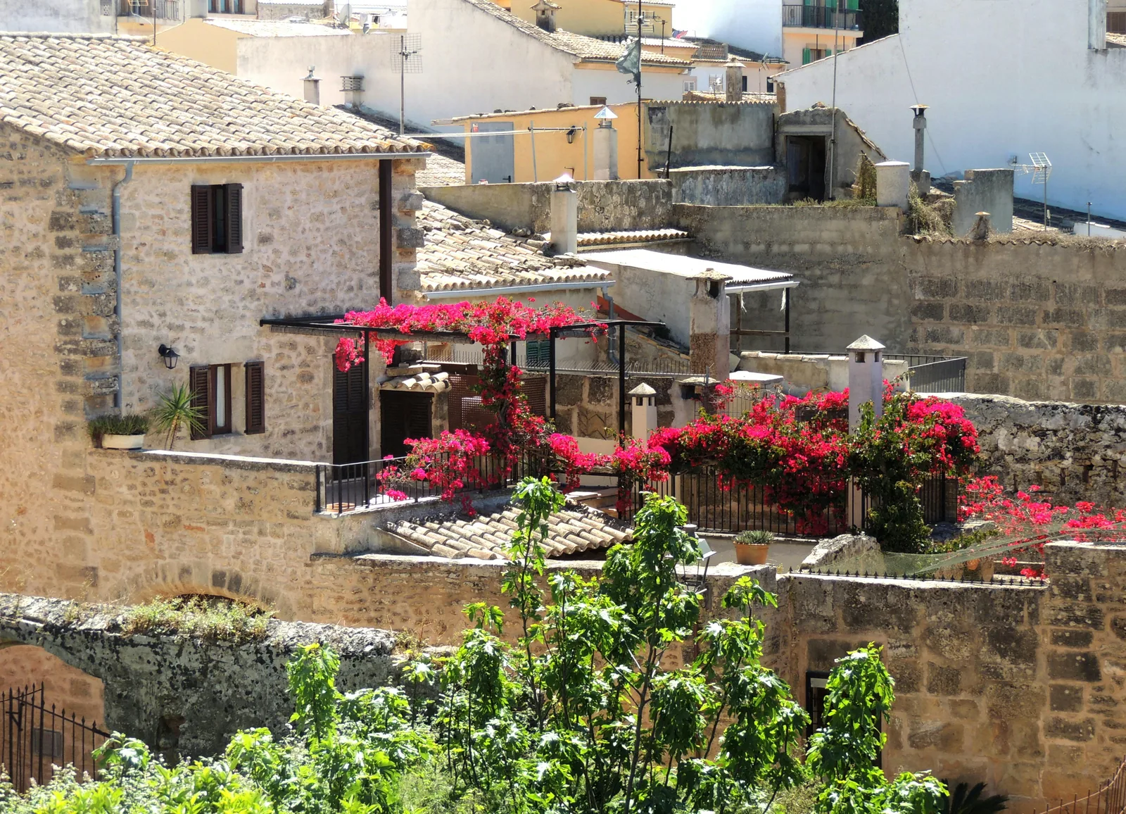 Ruelle en pierre et maisons fleuries dans la vieille ville d'Alcúdia