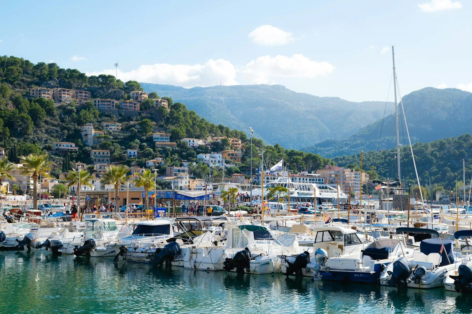 Marina animée du Port de Sóller avec ses bateaux et ses maisons à flanc de colline