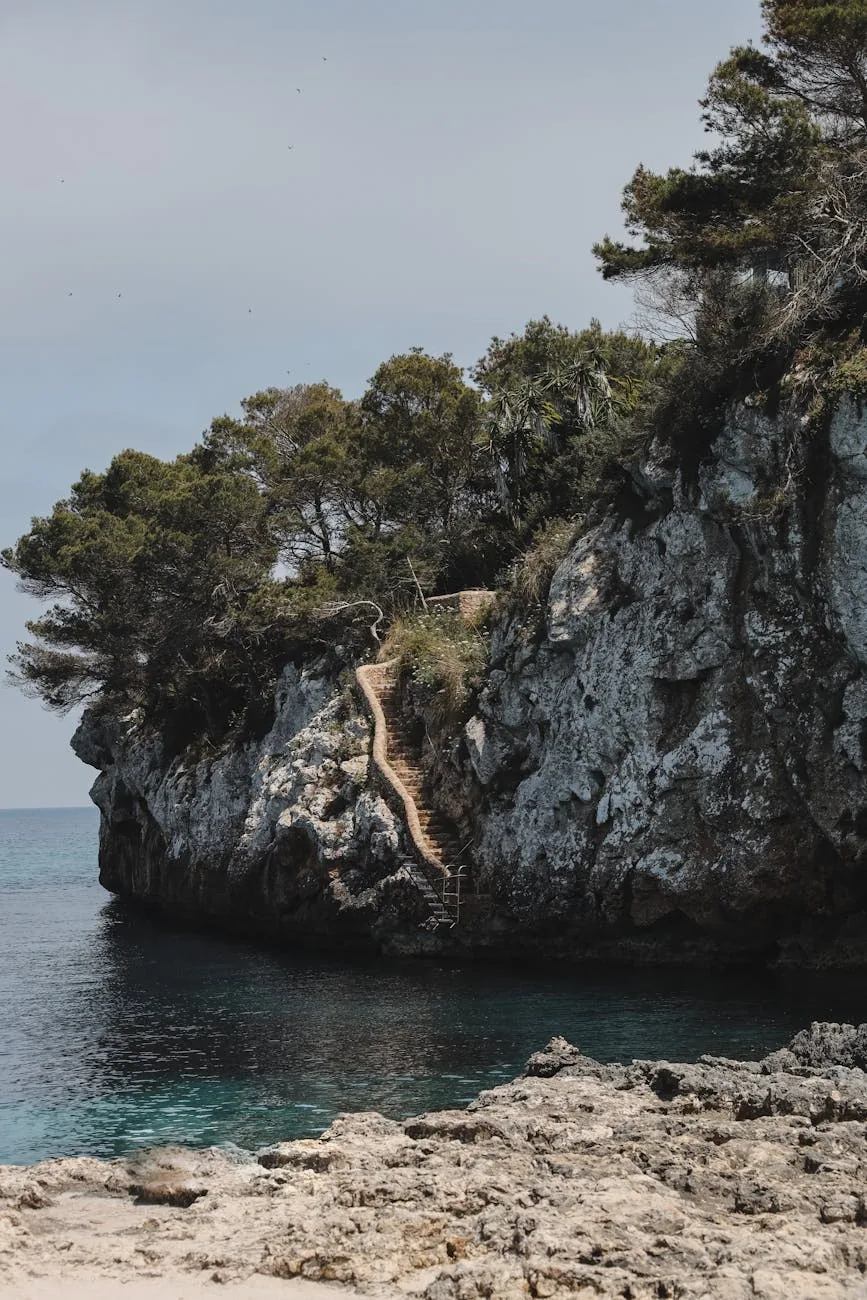 Falaise de Cala Llombards avec l'escalier taillé dans la roche descendant vers l'eau